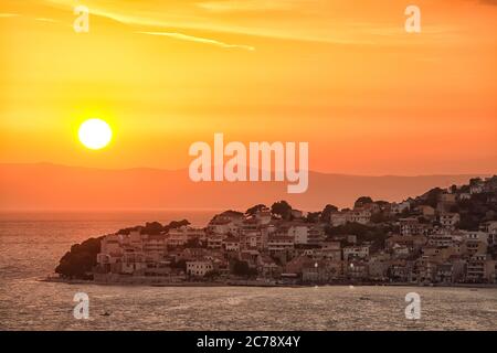 Panoramica del tramonto attraverso la splendida baia del villaggio di Igrane in Riviera di Makarska. Ubicazione: Igrane, riviera di Makarska, Dalmazia, Croazia, Europa Foto Stock