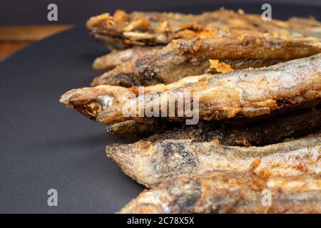 Pesce capelin fritto. Pesce piccolo, fritto in olio vegetale in padella. Foto Stock