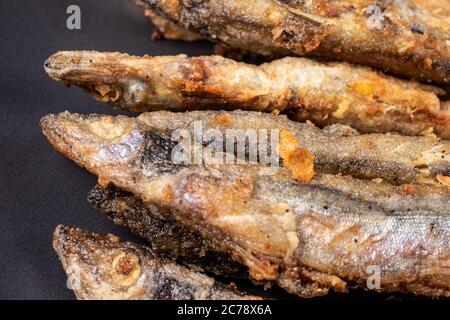 Pesce capelin fritto. Pesce piccolo, fritto in olio vegetale in padella. Foto Stock
