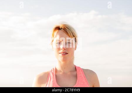 ritratto di una bella donna bionda con il cielo sullo sfondo, concetto di salute mentale e relax, copia spazio per il testo Foto Stock