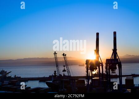 Vista silhouette delle gru presso le strutture portuali all'alba, Valparaiso, Valparaiso Regione, Cile, Sud America Foto Stock