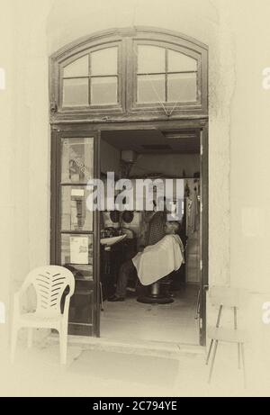 Lisbona, Portogallo - 22 agosto 2018. Barbiere nelle affascinanti strade di Alfama, il quartiere più antico di Lisbona (retrò bianco e nero, stile vintage Foto Stock