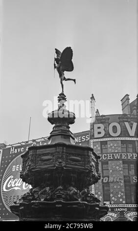 Fotografia d'epoca degli anni '50 di Piccadilly Circus a Londra, Inghilterra. Mostra i segni pubblicitari al neon dell'epoca. Foto Stock