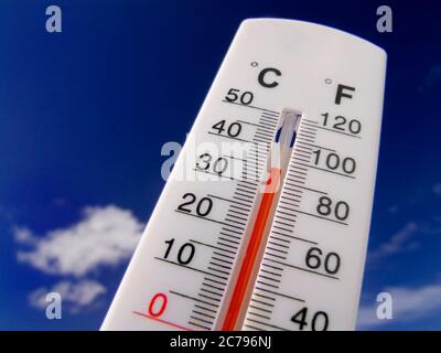 35C TEMPERATURA 93 F indicatore di temperatura A ONDA DI CALORE concetto di aumento rosso il termometro visualizza caldo e soleggiato 93F gradi lontano contro un cielo blu luminoso Foto Stock