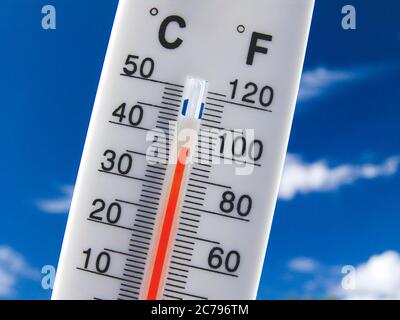 38C ONDA DI CALORE 100F indicatore di temperatura rosso crescente Concept termometro visualizza caldo e soleggiato 38C centigradi 100F gradi farenheit contro un cielo blu luminoso Foto Stock