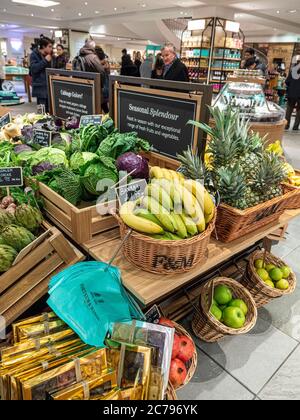 Fortnum & Mason Food Hall con esposizione aperta di frutta e verdura in vendita con le buste di carta riciclabile di marca Fortnum, collocate per un comodo acquisto. Ananas banane e mele in cesti di vimini. Fortnum & Mason Food Hall Department, Piccadilly St. James's, Londra W1A 1ER Foto Stock