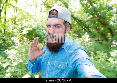 uomo mostra ok gesto. brutale hipster in foresta. scoprire nuovi posti. tempo per picnic. caucasico ragazzo con baffi. uomo maturo bearded fare selfie. estate campeggio vacanza. uomo hipster trekking. Foto Stock