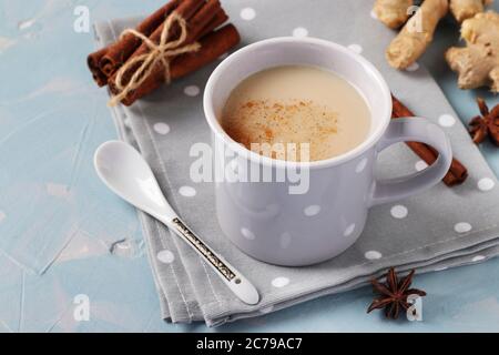 Tè tradizionale indiano masala con spezie in tazza grigia su sfondo azzurro, formato orizzontale Foto Stock