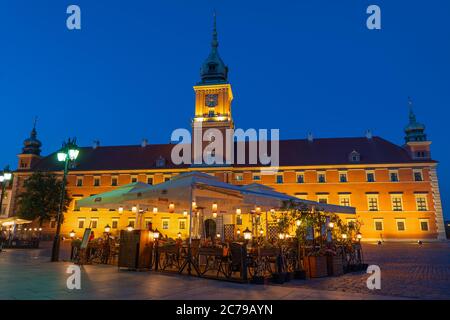 Castello reale illuminato di notte e tavoli ristorante all'aperto nella città di Varsavia, Polonia Foto Stock