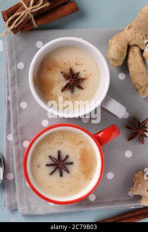 Tè tradizionale indiano masala con spezie in due tazze su sfondo azzurro, formato verticale, Vista dall'alto Foto Stock