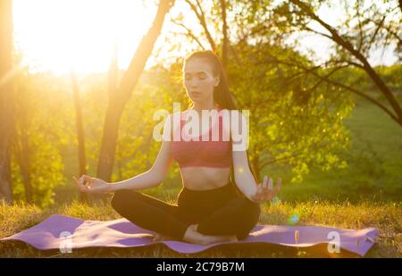 La ragazza pratica yoga all'aria fresca, piena di energia per il giorno. Foto Stock