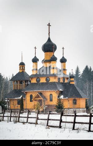 Chiesa di legno sotto la neve pesante a Dudutki, Bielorussia, a 25 chilometri di distanza da Minsk. Foto Stock