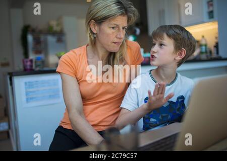 Madre e figlio utilizzando portatile a casa Foto Stock