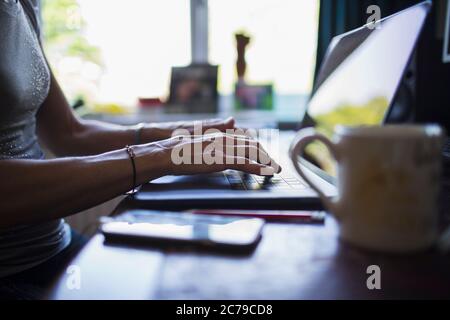 Primo piano donna che scrive sul laptop che lavora da casa Foto Stock