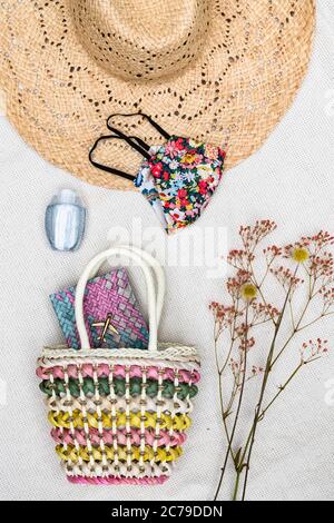 Coronavirus Covid-19 oggetti per le vacanze estive con maschera facciale, gel igienizzante per le mani, passaporto e cappello estivo pronti per una vacanza in spiaggia Foto Stock