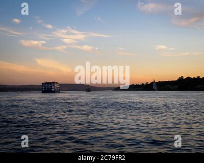 il sole sorge sul fiume nilo con barche a vela Foto Stock