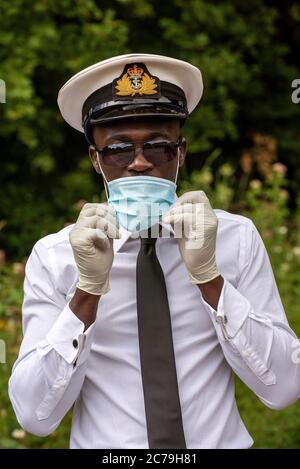 Hampshire, Inghilterra, Regno Unito. 2020. Un ufficiale navale che indossa guanti chirurgici e una maschera facciale durante l'epidemia di Covid-19 nel Regno Unito Foto Stock