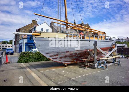 Barca a vela Manx Nobby White Heather in fase di riparazione sul molo al porto di Peel, Isola di Man Foto Stock