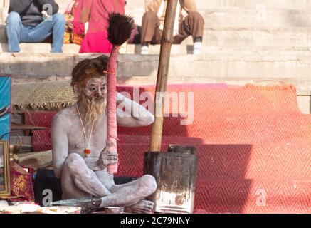 Un Naga Sadhu si siede di fronte alla sua tenda a. I ghat Varanasi Foto Stock