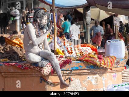 Un Naga Sadhu si siede di fronte alla sua tenda a. I ghat Varanasi Foto Stock