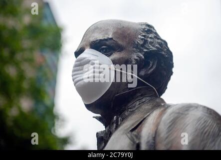 Leicester City durante il periodo di blocco prolungato a causa della pandemia di Coronavirus Covid-19. Statua di Thomas Cook con maschera di copertura davanti alla stazione ferroviaria. Foto Stock