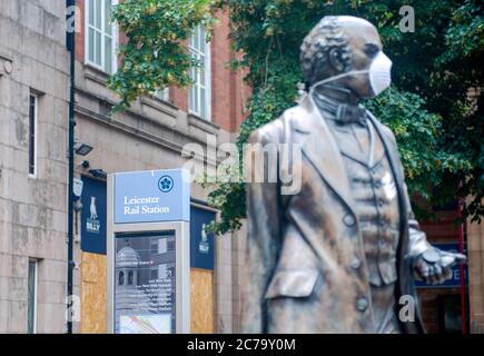 Leicester City durante il periodo di blocco prolungato a causa della pandemia di Coronavirus Covid-19. Statua di Thomas Cook con maschera di copertura davanti alla stazione ferroviaria. Foto Stock