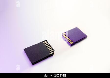 Due schede di memoria SD per fotocamere digitali, messa a fuoco selettiva, filtro viola Foto Stock
