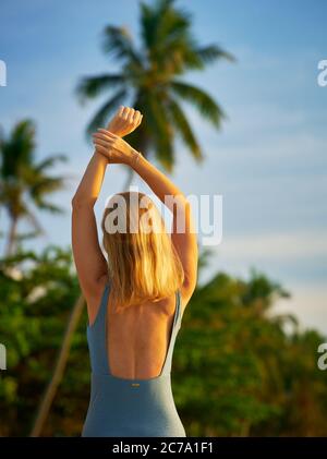 Bella donna su una spiaggia tropicale in Thailandia che si estende al sole del mattino Foto Stock