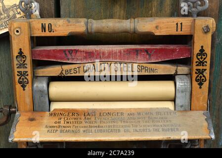 Antico strizzatore per rimuovere l'acqua dal lavaggio in mostra nel Museo di Likey, British Columbia, Canada. Foto Stock