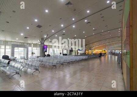 Un passeggero attraversa un terminal aeroportuale internazionale vuoto che mostra l'impatto che Covid 19 ha avuto sui voli, mentre gli aeroporti iniziano ad aprirsi di nuovo Foto Stock