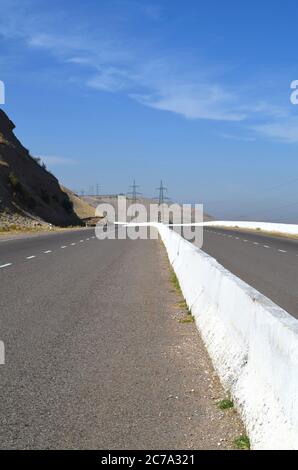 Autostrada vuota nelle montagne dell'Uzbekistan. Beldersay montagna. Foto Stock