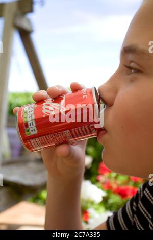 Giovane ragazza che beve una piccola lattina di coca cola Foto Stock