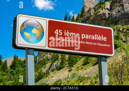 Segno rosso con globo che indica il 45° parallelo nelle Alpi francesi, vicino a Briançon Foto Stock