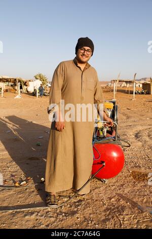 Riad, Arabia Saudita, febbraio 15 2020: Un giovane Saudita si alza con il suo compressore sul lato della strada e attende i piloti che vogliono gonfiare il loro Foto Stock