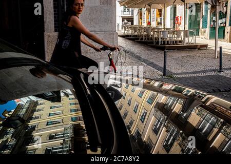 Lisbona, Portogallo - 23 Maggio 2020 : Donna in bicicletta nel centro di Lisbona Foto Stock