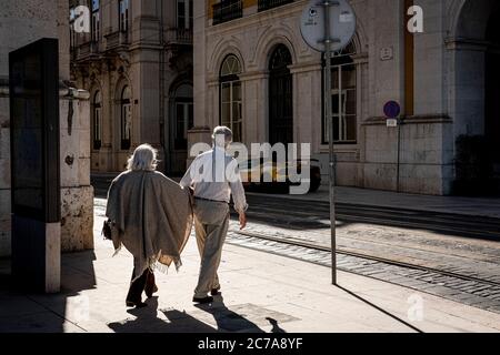 Lisbona, Portogallo - 23 maggio 2020 : coppia che tiene le mani per attraversare la strada Foto Stock