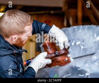 Blocco di ghiaccio per scultura con motosega elettrica Foto Stock