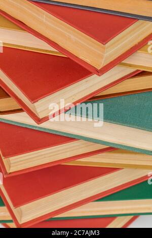 sfondo astratto libri - vecchi rossi e muti verdi in una pila verticale. Foto Stock