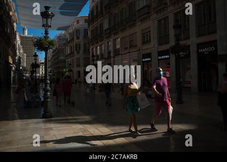 Malaga, Spagna. 15 luglio 2020. Una coppia che indossa maschere di fronte a piedi lungo la strada Marques de Larios durante il primo giorno di uso obbligatorio di maschere facciali.nuove infezioni da coronavirus in Spagna dopo l'allentamento delle restrizioni hanno fatto sì che il governo regionale imponga l'uso obbligatorio di maschere facciali all'aperto e luoghi chiusi e spiagge, anche quando osservano una distanza di sicurezza tra le persone. Questa misura cerca di frenare la diffusione della pandemia del coronavirus. Credit: Jesus Merida/SOPA Images/ZUMA Wire/Alamy Live News Foto Stock