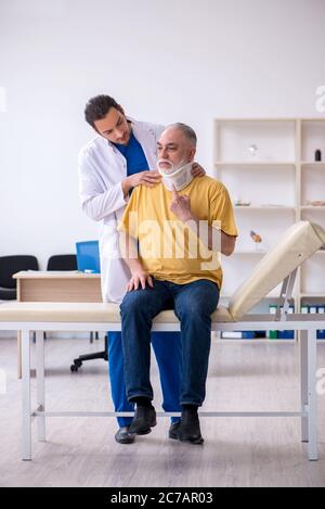 Vecchio collo ferito uomo in visita giovane medico Foto Stock