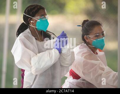 Austin, TX USA 15 luglio 2020:tecnici medici che lavorano per gli indumenti protettivi (PPE) di Austin Public Health ed eseguono proiezioni COVID-19 gratuite in un parco pubblico. Il Texas ha visto un enorme picco nei casi di coronavirus con quasi 300,000 casi che hanno provocato almeno 3,432 morti. Credit: Bob Daemmrich/Alamy Live News Foto Stock