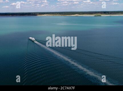 14 luglio 2020, Brandenburg, Sedlitz: Il serbatoio di trattamento delle acque Klara della Lausitzer und Mitteldeutsche Bergbau-Verwaltungsgesellschaft mbH (LMBV) sta diffondendo calce viva nelle acque del lago di Sedlitz per migliorare la qualità dell'acqua (foto aerea con un drone). La miniera a cielo aperto di Sedlitz è stata limata per conto della LMBV da giugno. Questa prima neutralizzazione viene effettuata con il proprio serbatoio di trattamento delle acque della LMBV Klara, già in funzione sul lago Partwitz. La misura dovrebbe essere effettuata entro la fine di settembre. Circa 10,000 tonnellate di cosiddetto quicklim Foto Stock
