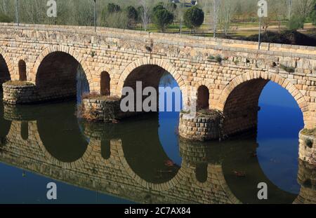 Merida, Provincia di Badajoz, Estremadura, Spagna. Il ponte romano che si riflette sul fiume Guadiana. Sito patrimonio dell'umanità dell'UNESCO. Foto Stock