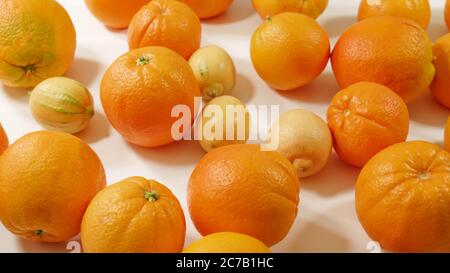 Arance e limoni su sfondo bianco. Frutta fresca matura da vicino, vista dall'alto. Foto Stock