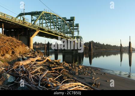 Bullards Bridge a Bandon, Oregon. Driftwood in primo piano. Foto Stock