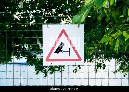 Cartello di avvertenza su recinzione per telecamere di sorveglianza di sicurezza nell'area. A riga, Lettonia alla crociera, porto dei traghetti, terminal. Foto Stock