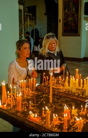 Persone che illuminano candele nella Cattedrale di Etchmiadzin, che è la chiesa madre della Chiesa Apostolica Armena, situata nella città di Vagharshapat Foto Stock