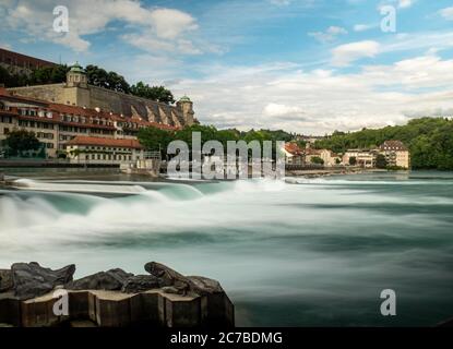 Lunga esposizione, basso angolo di un fiume che scorre rapidamente e edificio del Parlamento a Berna, capitale della Svizzera. Foto Stock