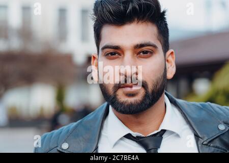 Un uomo dal bearded indiano vestito con stile cammina lungo la strada. Foto Stock