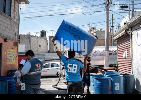 Mexiko Stadt, Messico. 15 luglio 2020. Un uomo porta un barile d'acqua. Il Messico è ora il paese con la quarta morte più registrata per malattia polmonare di Covid-19. Credit: Jacky Muniello/dpa/Alamy Live News Foto Stock